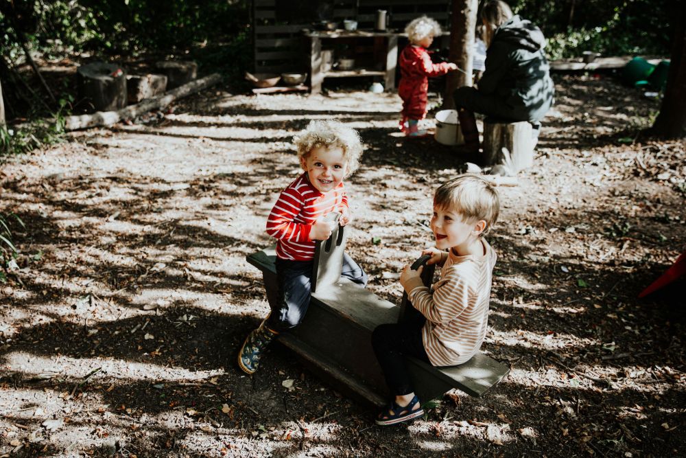 Children on a seesaw at a child led steiner forest school parent and child session
