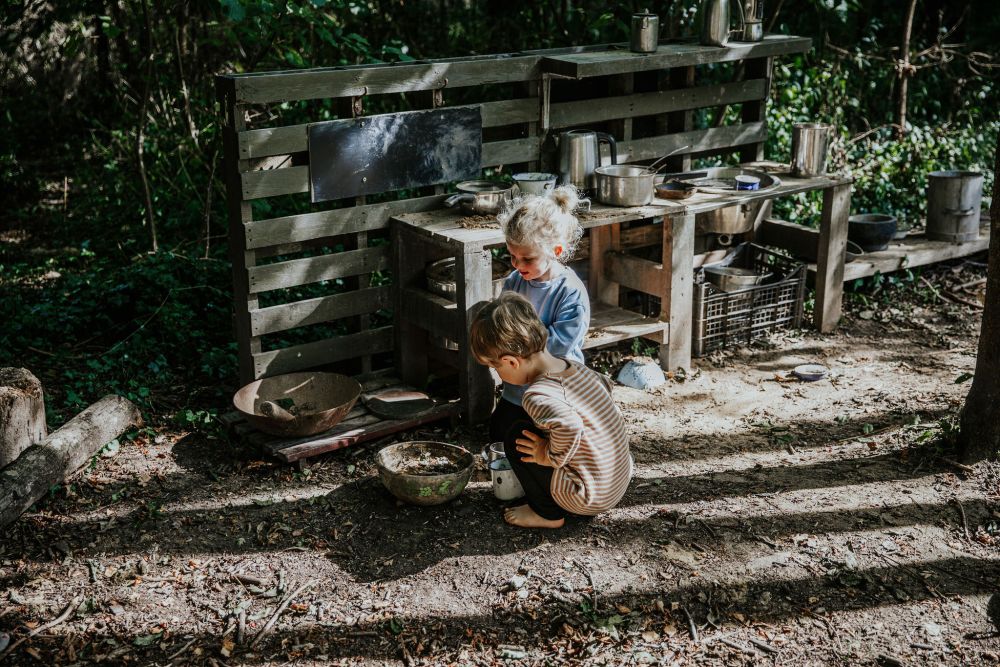 Children playing in the mud kitchen at the forest school parent and child session